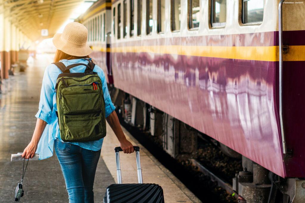 Young woman at a train station (tips for sustainable travel)