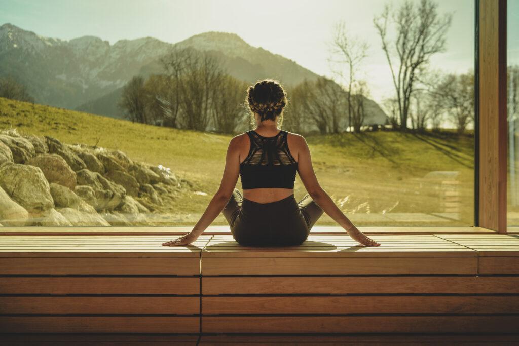 A woman looks out at the mountain panorama from the relaxation room at Hotel Klosterhof