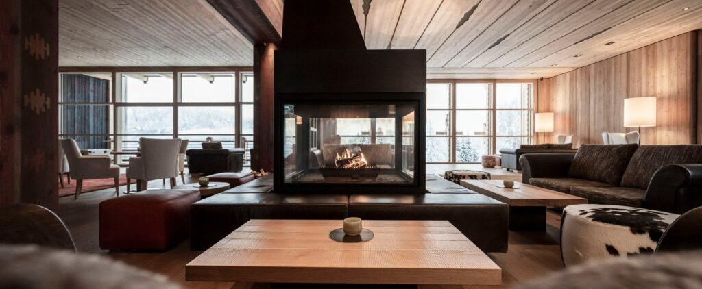 A romantic and sustainable hotel on the Ritten with a lobby featuring a fireplace.