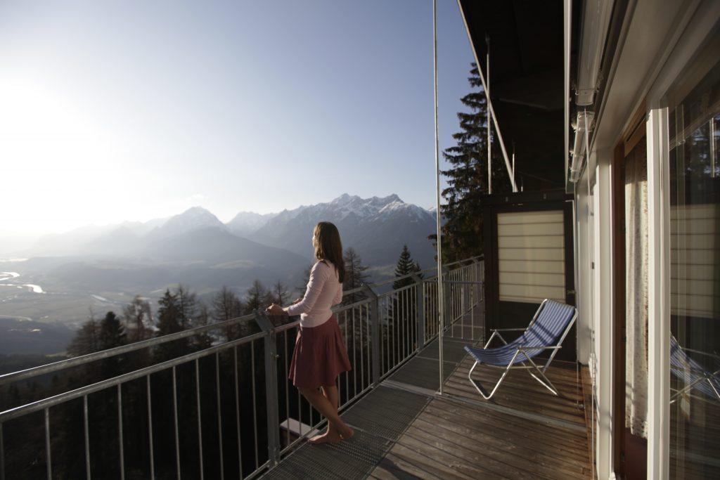 Woman looking at the Tyrolean Inn Valley from the terrace of the Biohotel Grafenast.