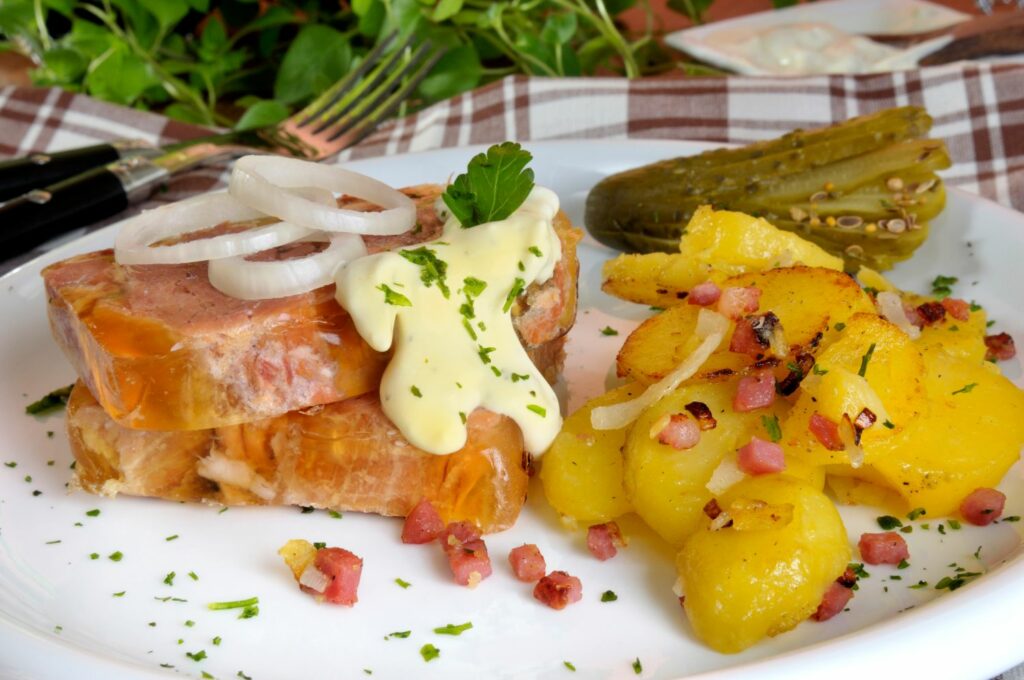Holsteiner Sauerfleisch (marinated beef) with fried potatoes and gherkinse