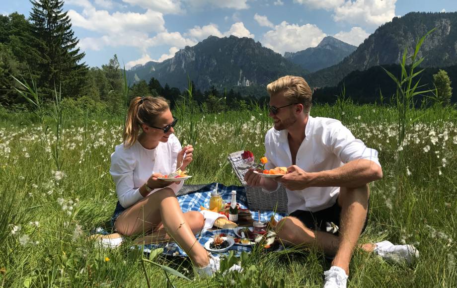 A couple is picnicking on the lawn.