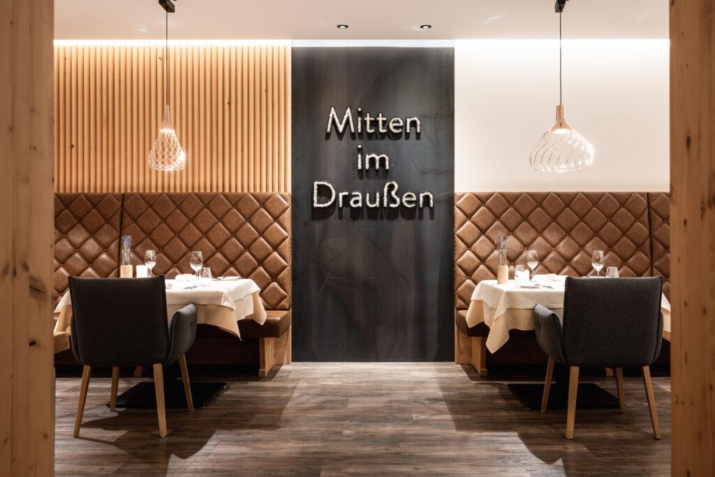 Blick ins Restaurant mit dem Slogan "Mitten im Draußen" an der Wand