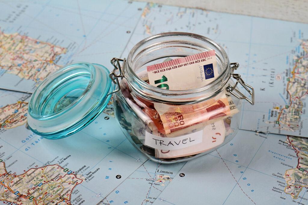 Piggy bank on travel tourist map. Saving money for sustainable travel, planning holiday or vacation