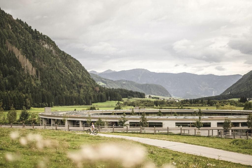 OLM Nature Escape in Sand in Taufers in South Tyrol. Exterior view of the aparthotel with view of the sky and the mountains. An example of sustainable architecture.