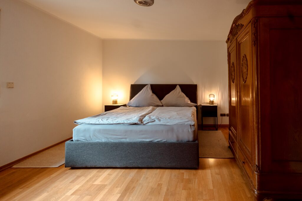 The rooms at Hotel Okelmanns in Warpe are decorated in a sustainable and cozy style with a bed and wardrobe.