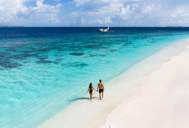 Couple walking along a Maldivian beach © Reethi Faru Resort