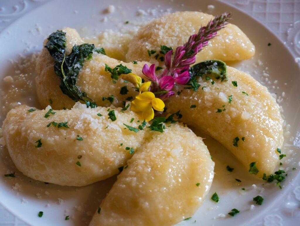 Schlutzkrapfen with Parmesan cheese and flowers on the plate