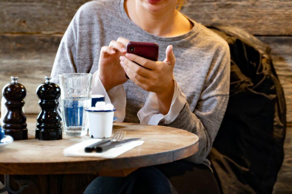 Woman with smartphone sitting in cafe