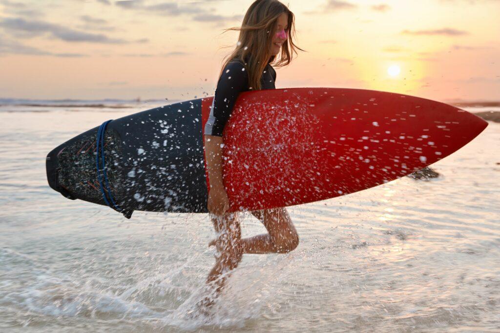 A surfer with a surfboard in the sunset
