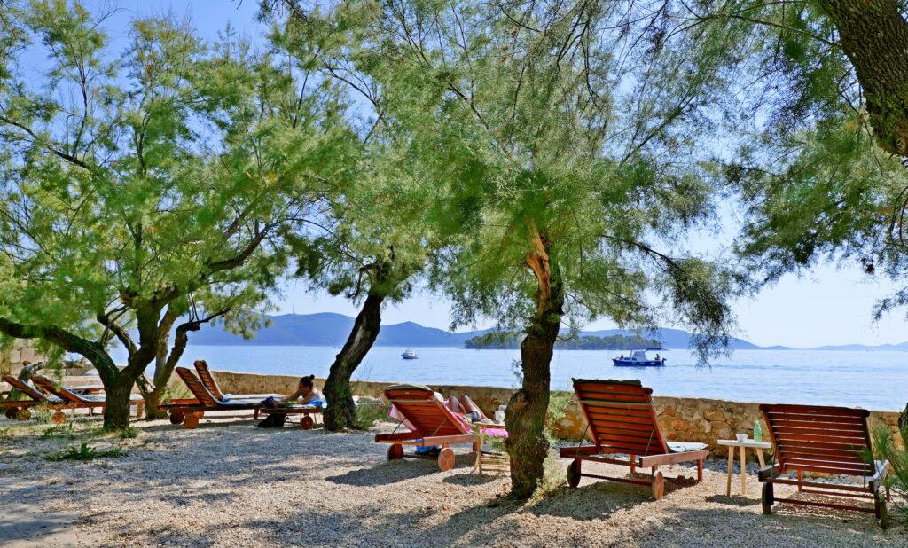 Promenade on the island of Iz in Croatia with sun loungers