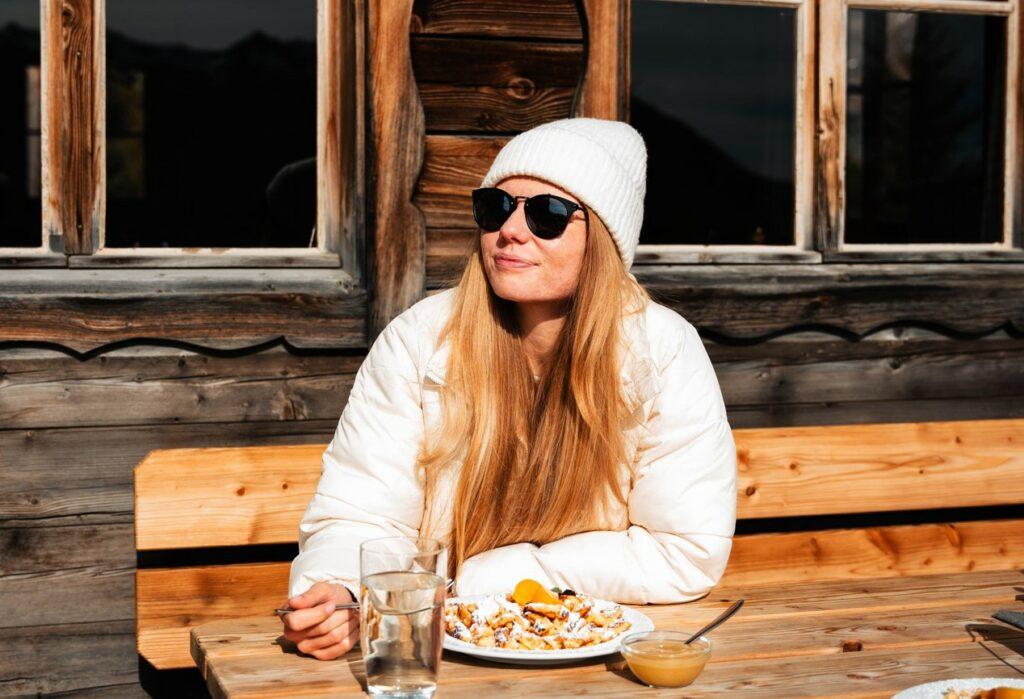 Woman on the terrace of a mountain hut in the sunshine.