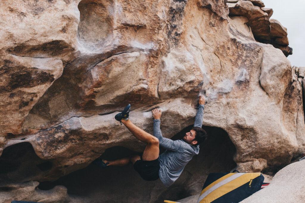 Sustainable activities on vacation - Man boulders outside with a heel hook