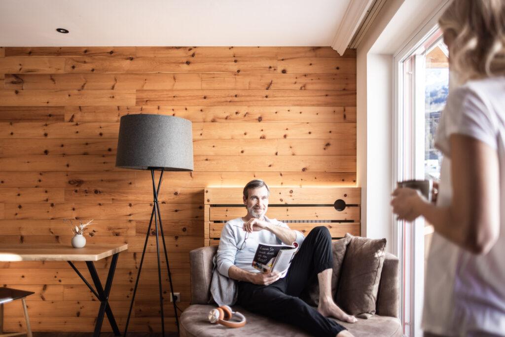 A couple relaxes in the Swiss stone pine suite at Naturhotel Outside.