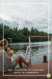 A woman relaxes on a deck of the eco glamping resort Canvas & Orchids Retreat in Cambodia with a coconut, overlooking a serene river and lush green palm trees in Cambodia. Text reads "Canvas & Orchids Retreat."