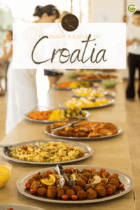 Buffet table with assorted vegetarian Croatian dishes on silver platters at the sustainable Hotel Korinjak on the island of Iz near Zadar. Including fried croquettes and colorful salads. People in the background, warm ambiance.