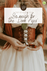 Close-up of a person in a medieval-style dress with a leather corset. They hold red berries and white flowers, conveying a historic and rustic feel.