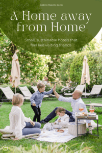 A family having a picnic on a grassy area at the sustainable hotel Relais del Maro; with trees and sun loungers in the background. A child gives an adult a high five, evoking warmth and connection.