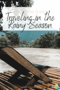 Bamboo terrace on a river surrounded by lush green trees and distant hills under an overcast sky. Text reads, "Traveling in the Rainy Season."