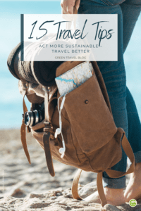 The pin shows the legs of a young woman standing barefoot in the sand of a beach. She has a small backpack with a rolled up blanket in her hand. A map is in the side pocket and a camera in the front.